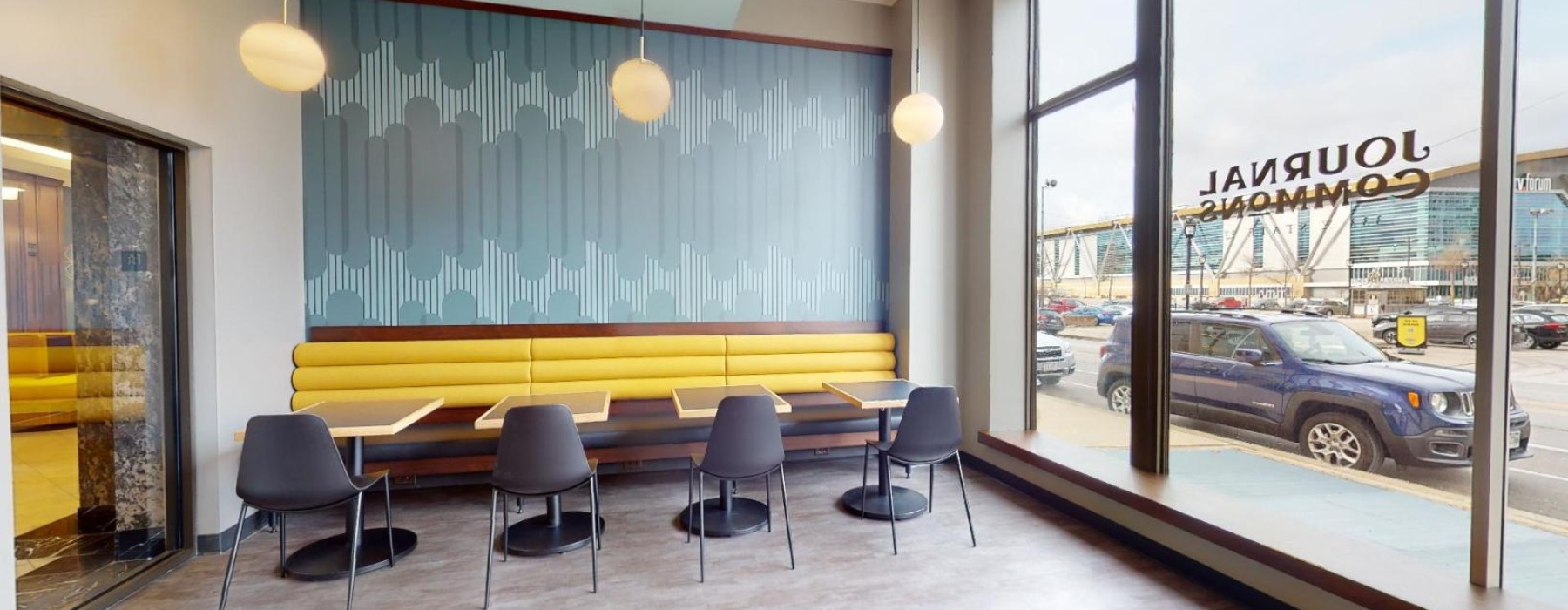 a room with tables chairs and a large windows