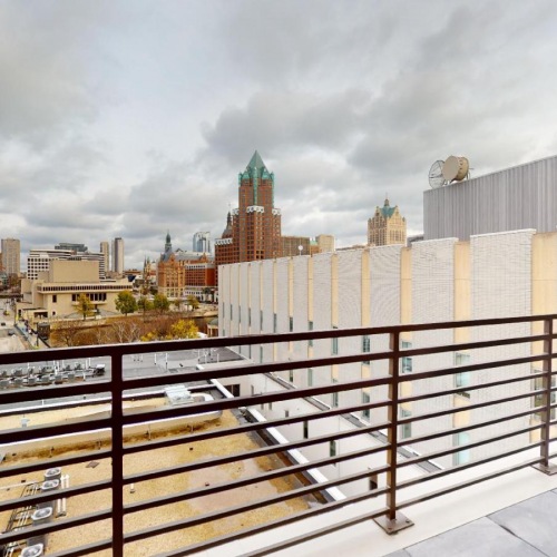 The essence of exceptional living a rooftop patio with a railing and buildings in the background