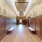 a room with a wood floor and white walls with art on it